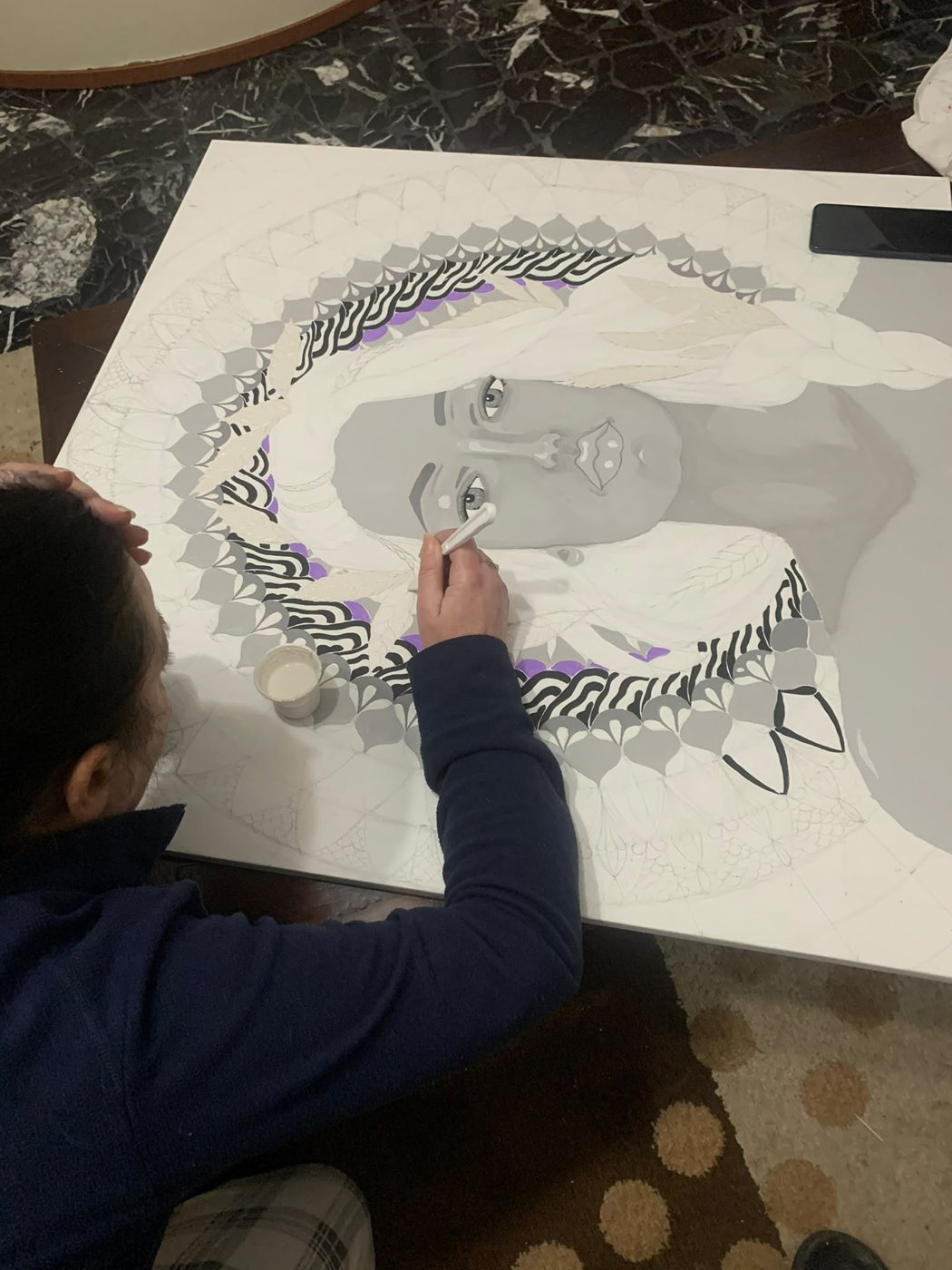 Malugho at work on a portrait with mandala